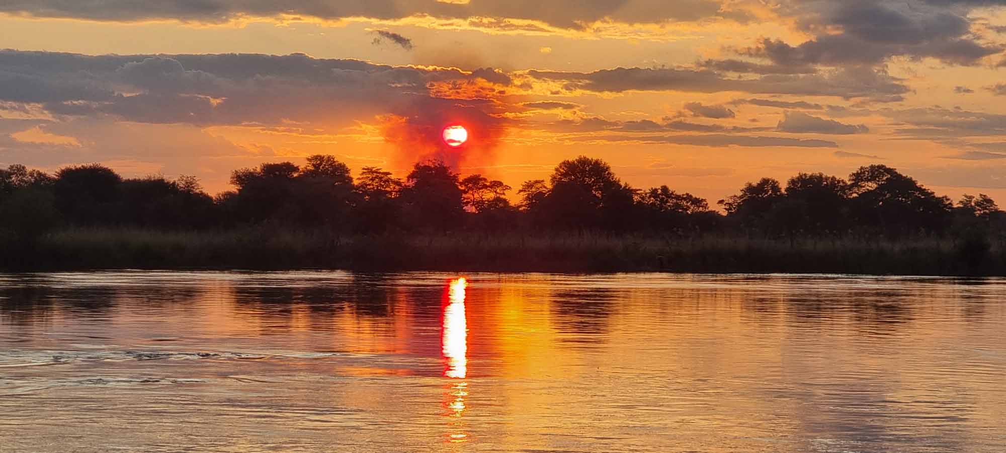 Sonnenuntergang über dem Zambezi-Fluss im Caprivi-Streifen der Zambezi-Region in Namibia.