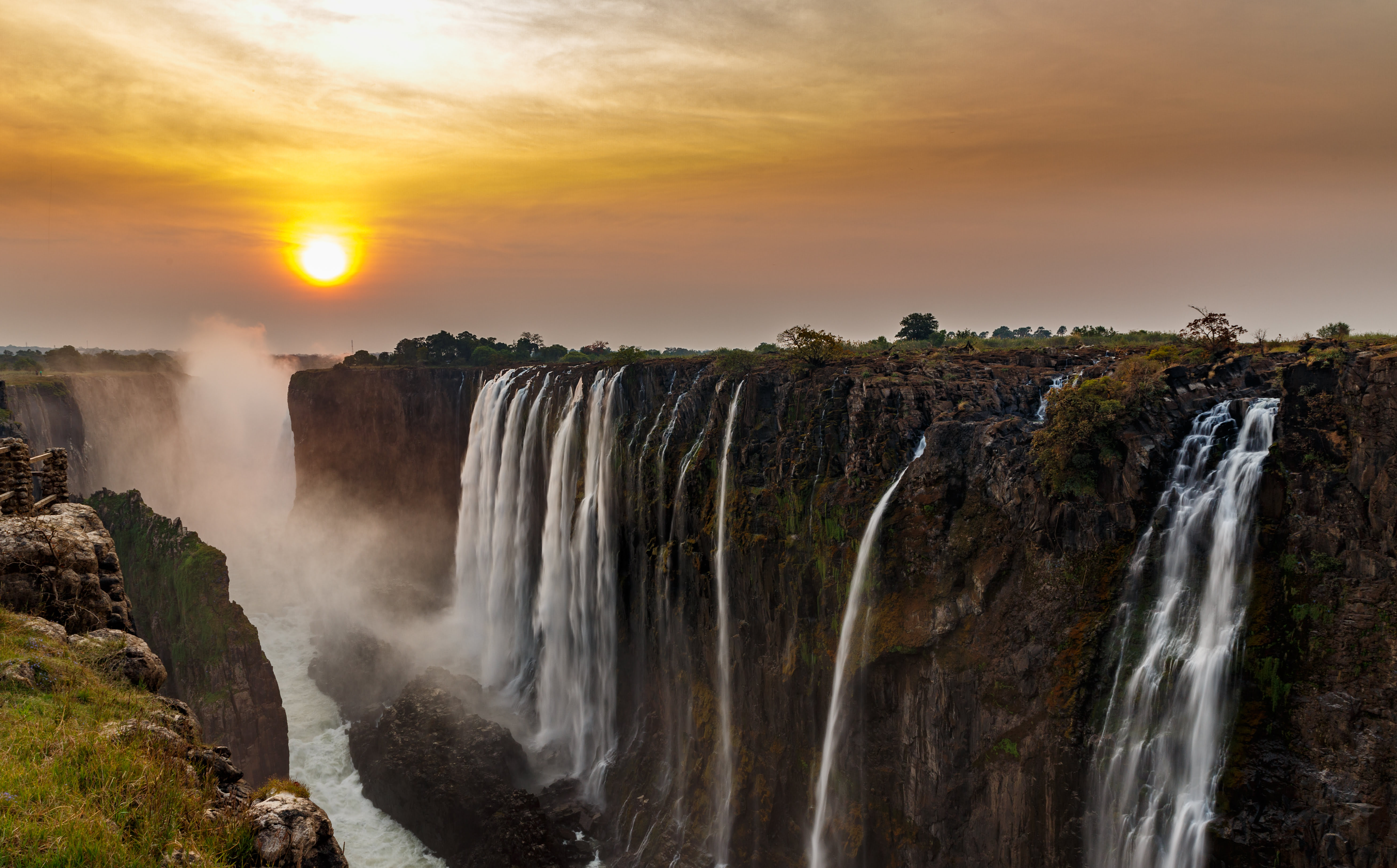 Victoria Falls bei Sonnenuntergang in Zimbabwe, wo der Sambesi spektakulär in die Schlucht stürzt.